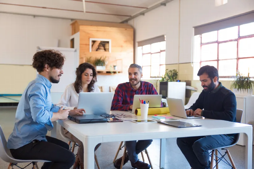 Product team planning an MVP scope together around a laptop
